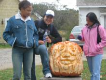Jenny, Guadalupe, and Ana with the giant carved pumpkin
